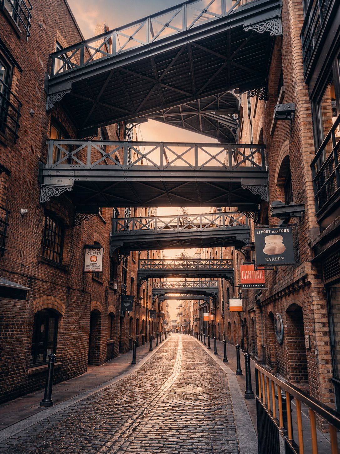 Victorian brick warehouses and iron pedestrian bridges at Shad Thames — depth, heritage, enduring partnership